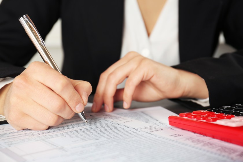 Woman filling individual income tax return form, closeup
